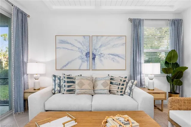 a living room with furniture large window and wooden floor
