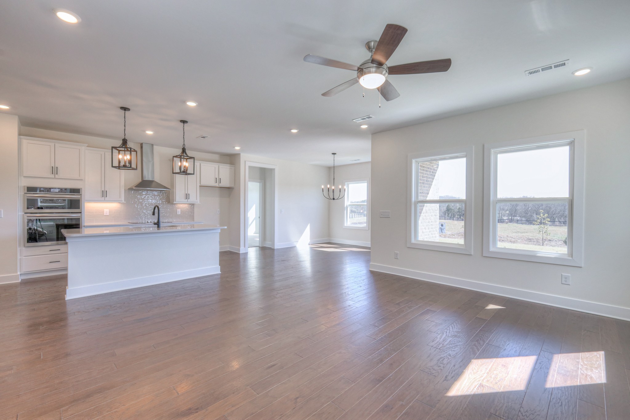 608 Phoebe Way Gallatin, TN 37066 - Photo 18 of 40 a view of an empty room and kitchen with wooden floor