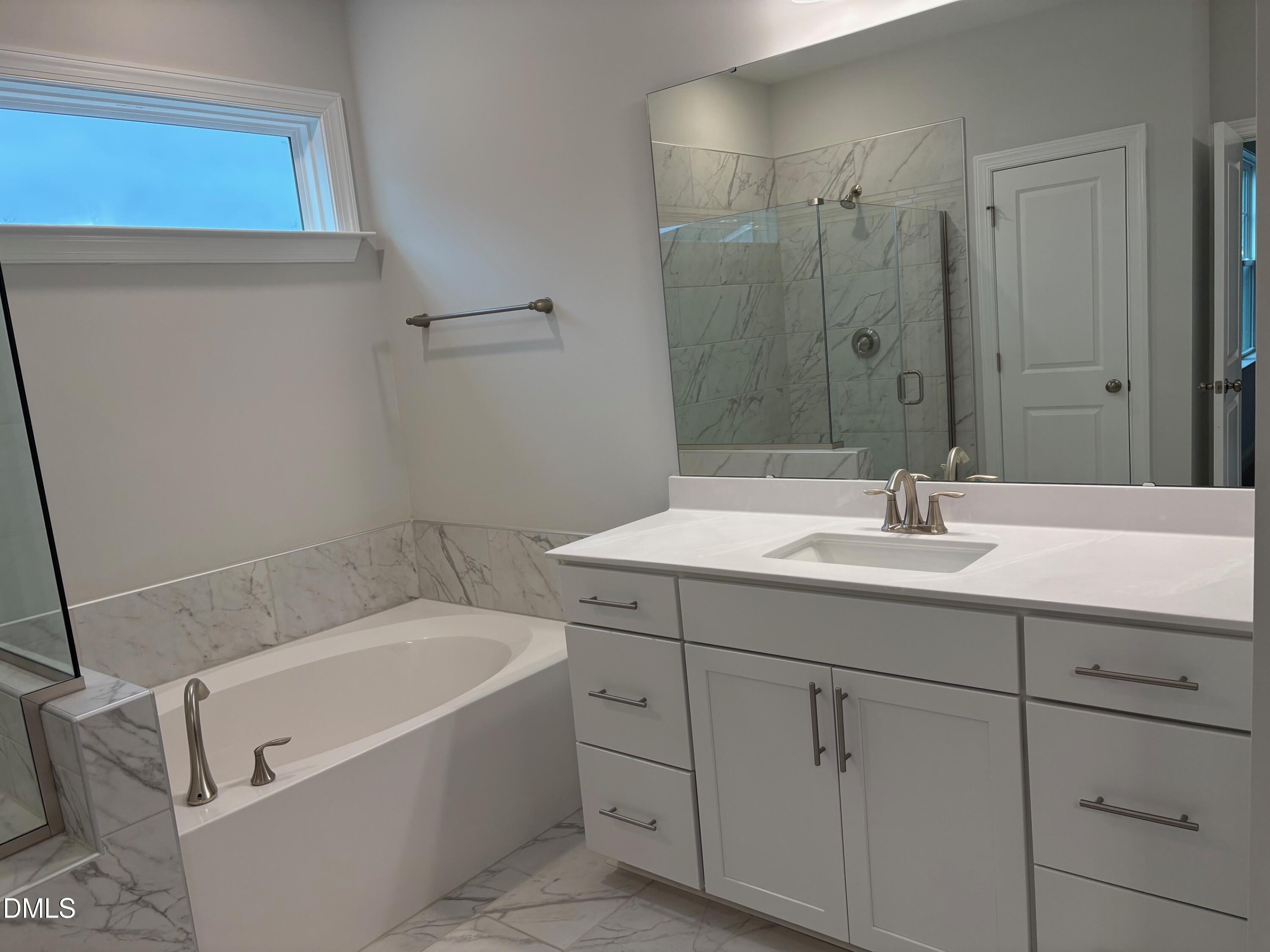 136 Corapeake Way Apex, NC 27539 - Photo 14 of 27 a bathroom with a tub sink and mirror