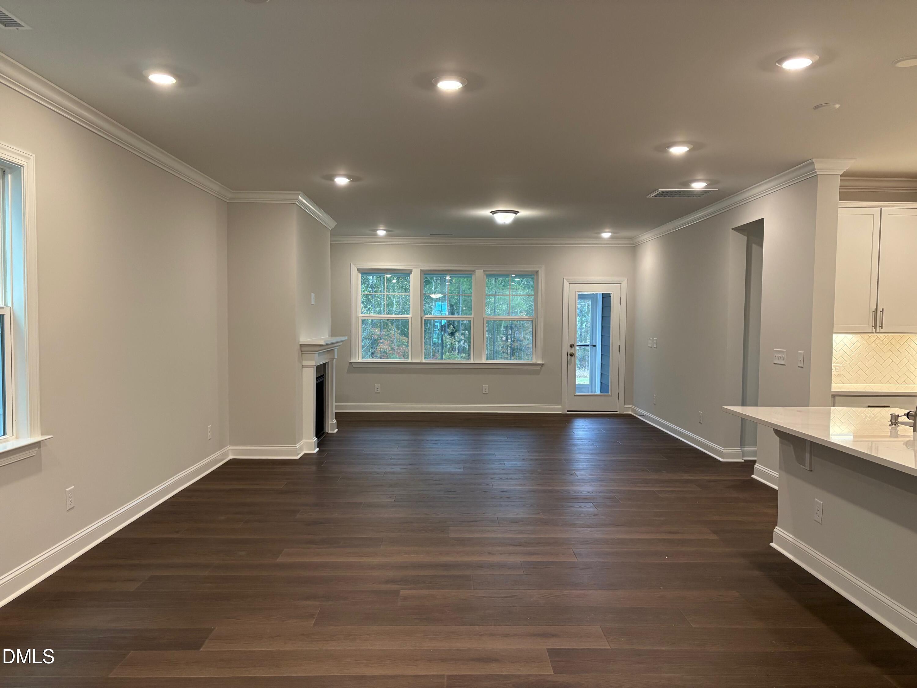 136 Corapeake Way Apex, NC 27539 - Photo 4 of 27 an empty room with wooden floor and windows