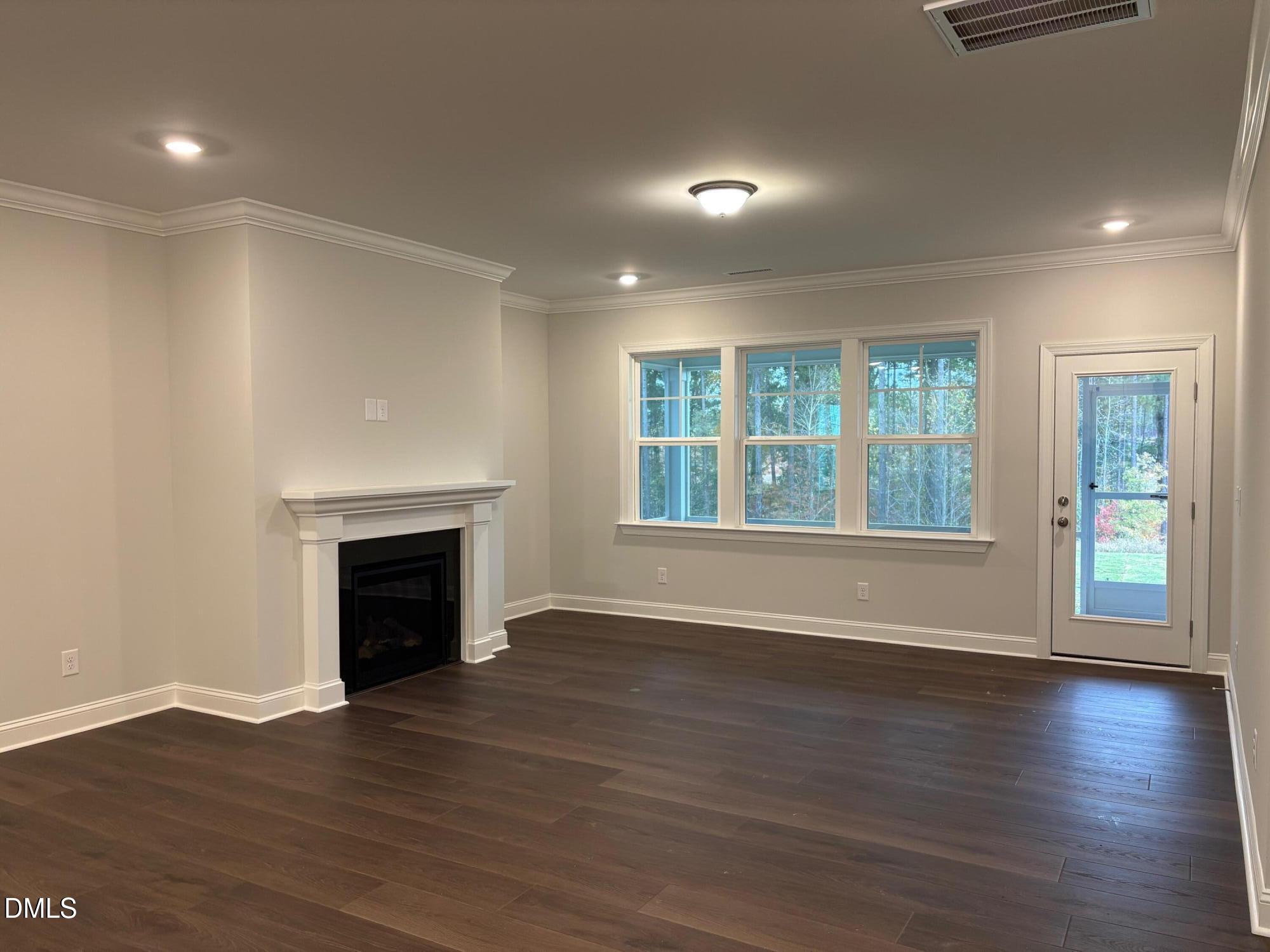 136 Corapeake Way Apex, NC 27539 - Photo 5 of 27 a view of an empty room with wooden floor and a window