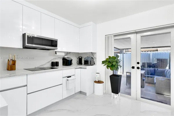 a kitchen with stainless steel appliances kitchen island granite countertop a sink a microwave a refrigerator and cabinets