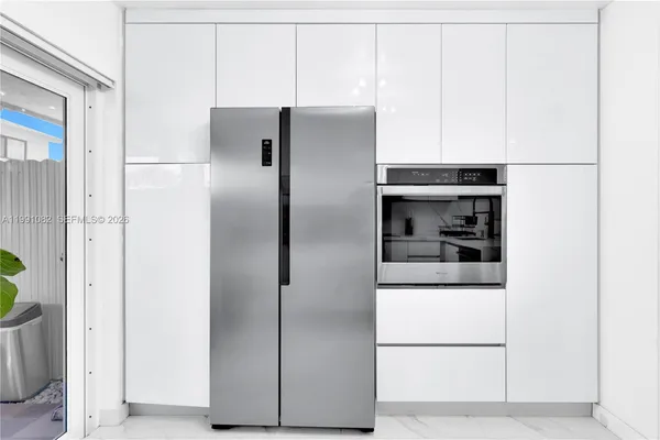 a metallic refrigerator freezer sitting in a kitchen