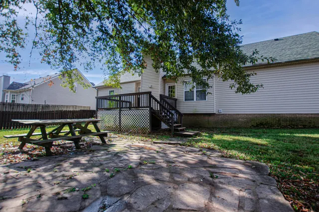 a view of backyard with table and chairs and a large tree