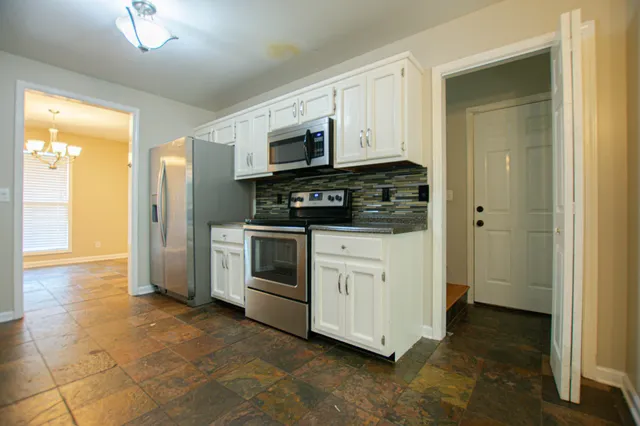 a kitchen with stainless steel appliances granite countertop a stove and a sink