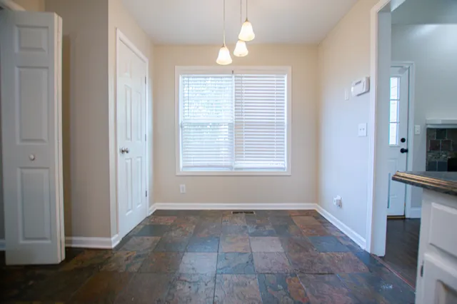 a view of kitchen with granite countertop cabinets and window