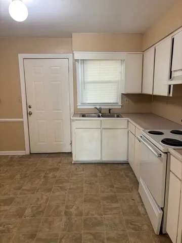 a kitchen with stainless steel appliances a sink a stove a refrigerator and cabinets