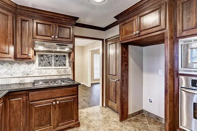 a kitchen with stainless steel appliances granite countertop a refrigerator and a stove