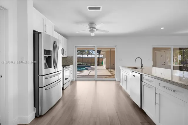 a kitchen with stainless steel appliances a refrigerator sink and cabinets