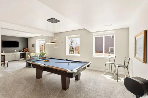 a living room with furniture pool table and flat screen tv
