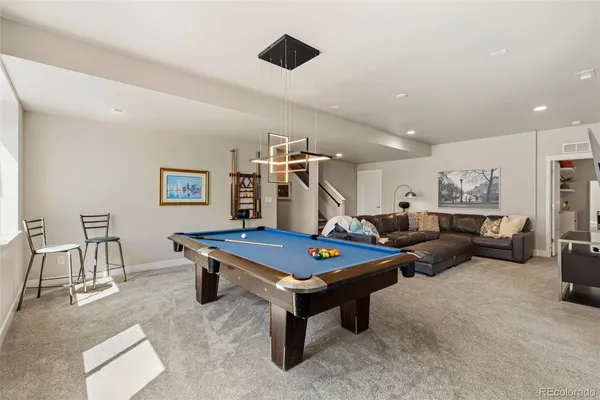a living room with furniture pool table and window
