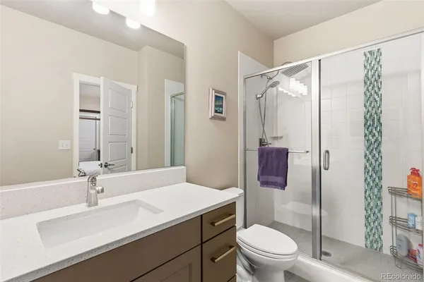 a bathroom with a sink toilet vanity and shower