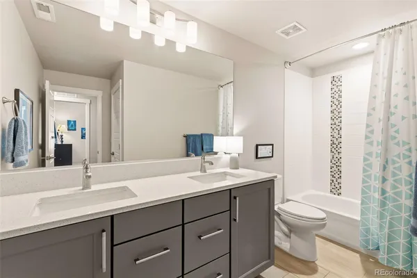 a bathroom with a double vanity sink toilet and a mirror