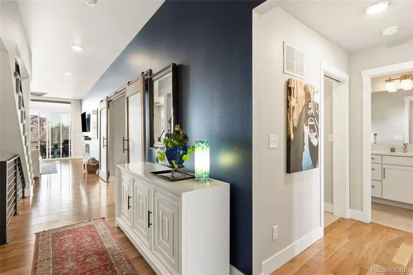 a hallway with white cabinets and wooden floor