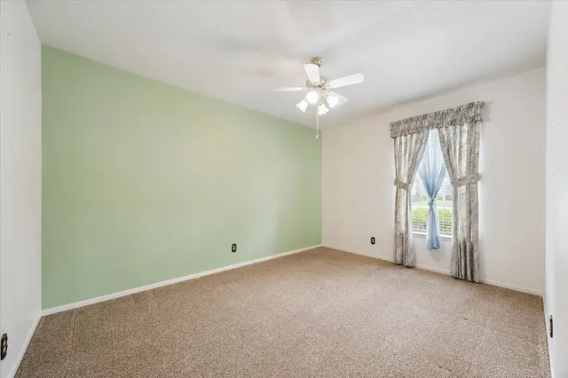 an empty room with a empty space and a ceiling fan