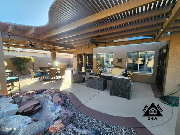 a view of a swimming pool with a table and chairs in patio