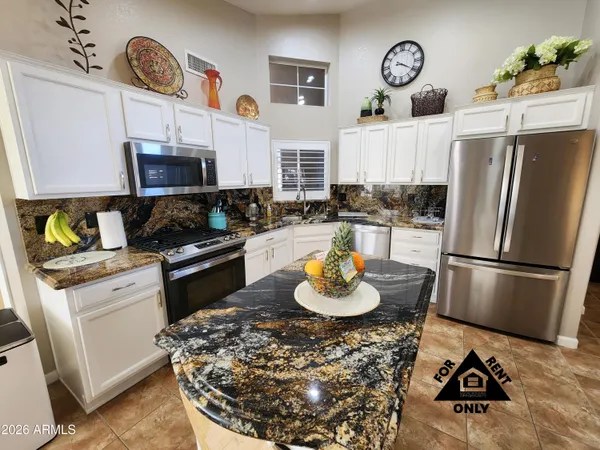 a kitchen with a refrigerator and a stove top oven