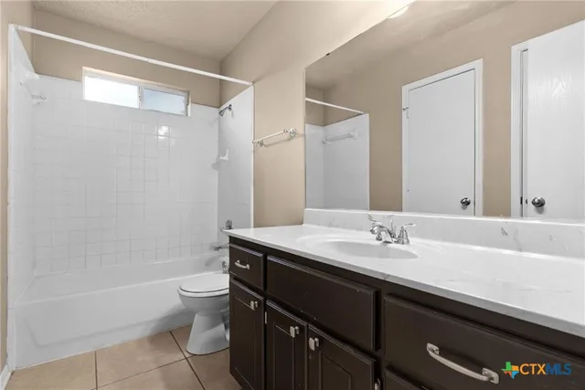 a bathroom with a granite countertop sink a toilet and shower