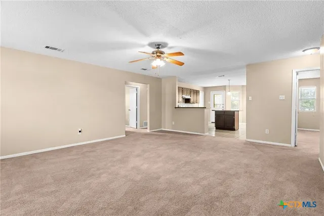 an empty room with closet and a ceiling fan