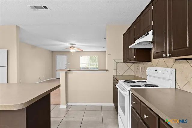 a kitchen with a sink a stove and cabinets