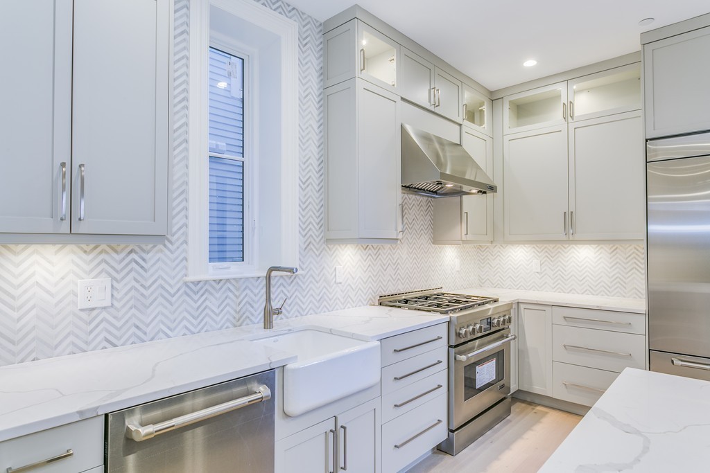 a kitchen with granite countertop a sink stainless steel appliances and cabinets