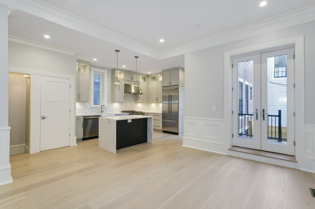 47 Chestnut Street, Unit 1 Boston, MA 02129 - Photo 2 of 17 a large white kitchen with kitchen island a sink stainless steel appliances and cabinets