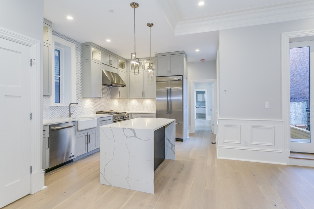 47 Chestnut Street, Unit 1 Boston, MA 02129 - Photo 7 of 17 a kitchen with stainless steel appliances granite countertop a sink a stove a refrigerator and island with wooden floor