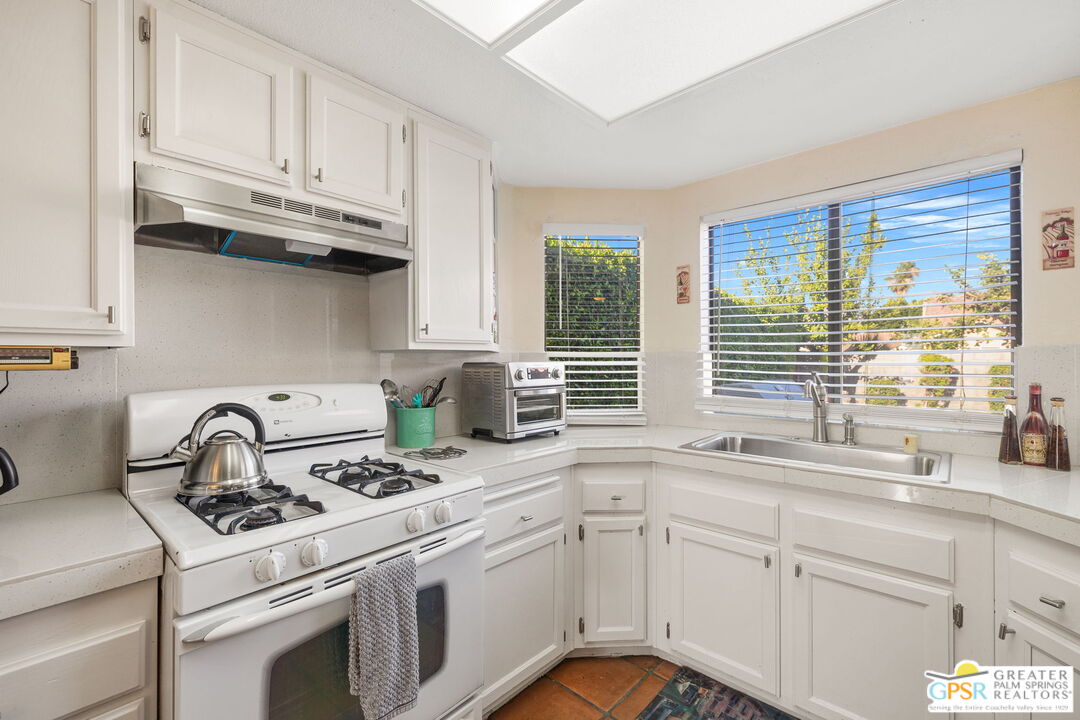 45688 Sutter Creek Road Indio, CA 92201 - Photo 14 of 51 a kitchen with stainless steel appliances granite countertop a sink a stove and cabinets
