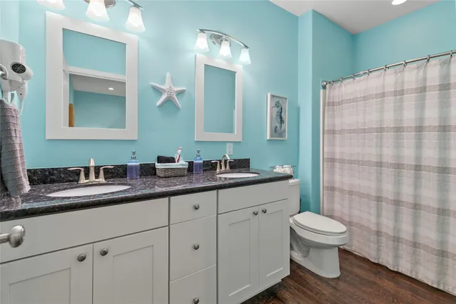 a bathroom with a double vanity sink toilet and shower