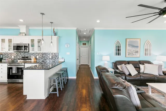a kitchen with stainless steel appliances kitchen island granite countertop a table chairs and a refrigerator