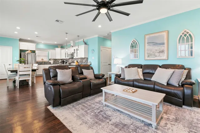 a living room with furniture and a view of kitchen