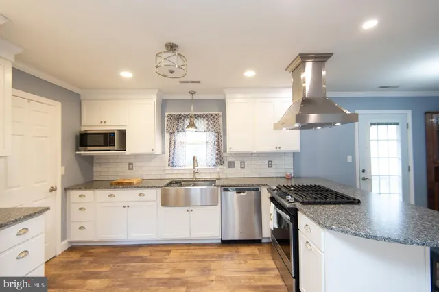a kitchen with stainless steel appliances granite countertop a sink a stove and a refrigerator