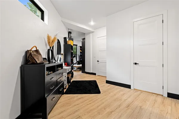 a walk in closet with wooden floor