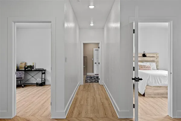 a view of a bedroom with a bed and wooden floor