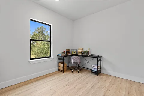 a view of a workspace with furniture and a window