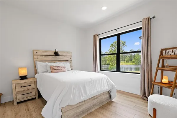 a bedroom with a bed a dresser next to a window