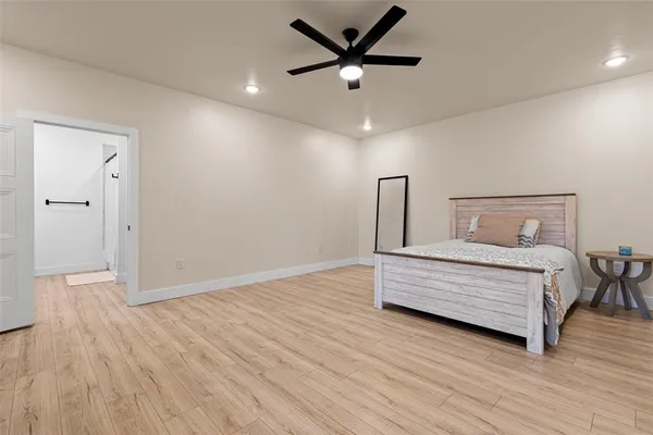 a bedroom with a bed and a ceiling fan