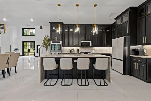 a kitchen with a dining table chairs and refrigerator