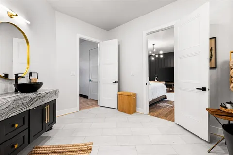 a bathroom with a granite countertop sink a mirror and shower