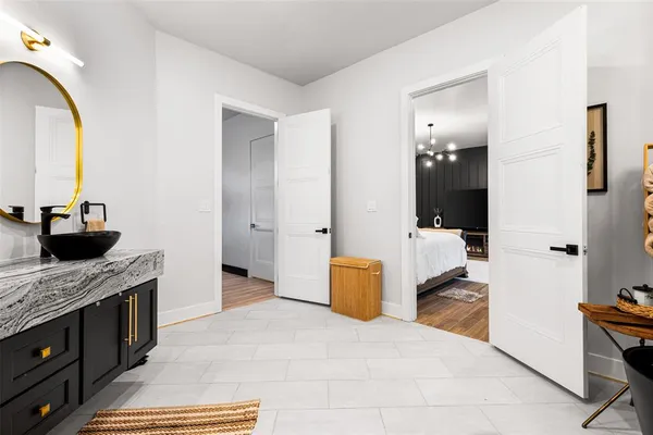 a bathroom with a granite countertop sink a mirror and shower
