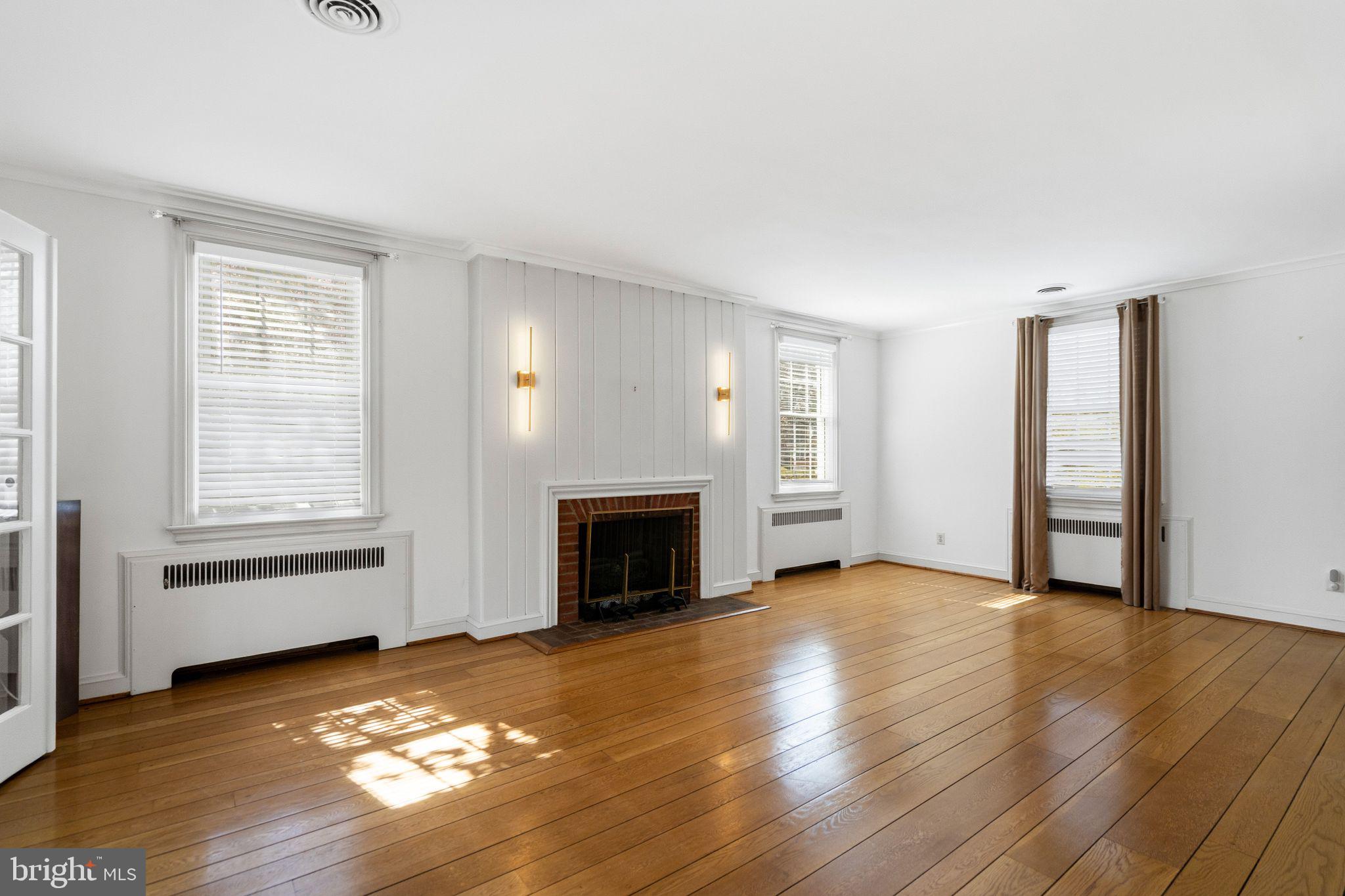 2116 Branch Avenue Southeast Washington, DC 20020 - Photo 7 of 32 an empty room with wooden floor fireplace and windows