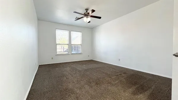 an empty room with a window and a ceiling fan