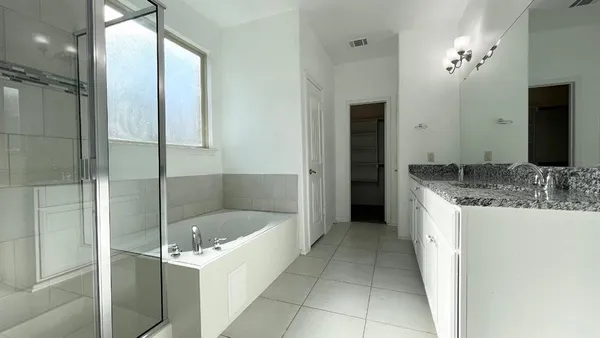 a bathroom with a tub sink and mirror