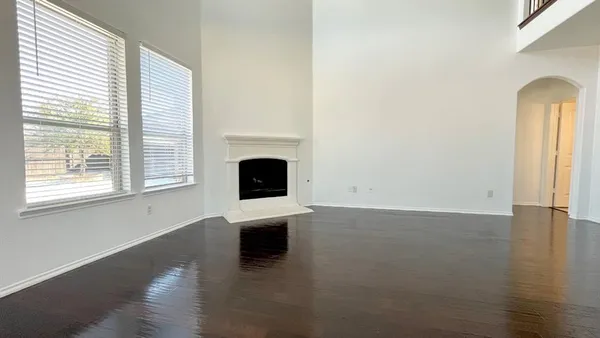 a view of empty room with wooden floor and fireplace