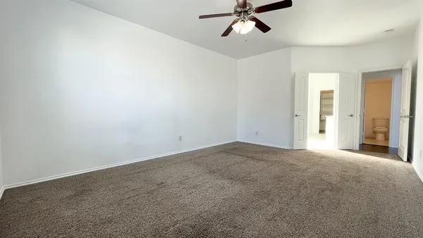 a view of a big room with windows and chandelier fan