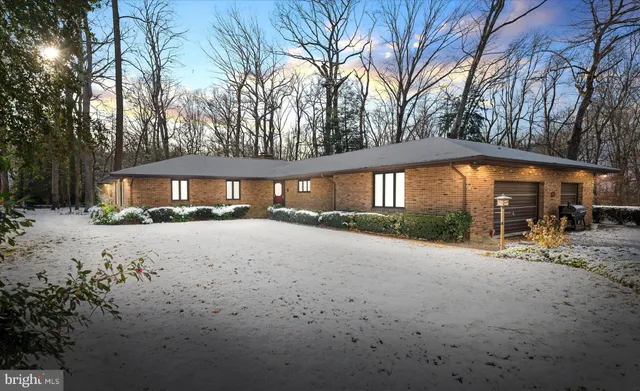a front view of house with yard and trees around