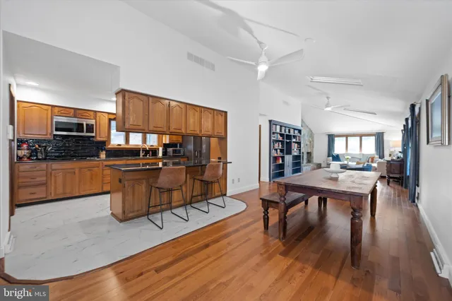 a living room with furniture appliances and wooden floor