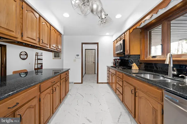 a large kitchen with stainless steel appliances granite countertop a sink and cabinets