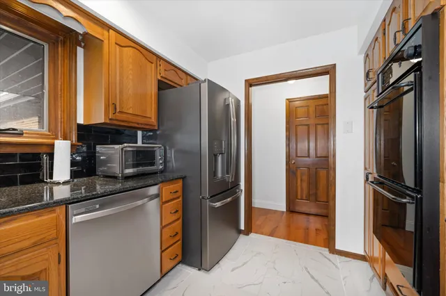 a kitchen with stainless steel appliances granite countertop a refrigerator and a sink