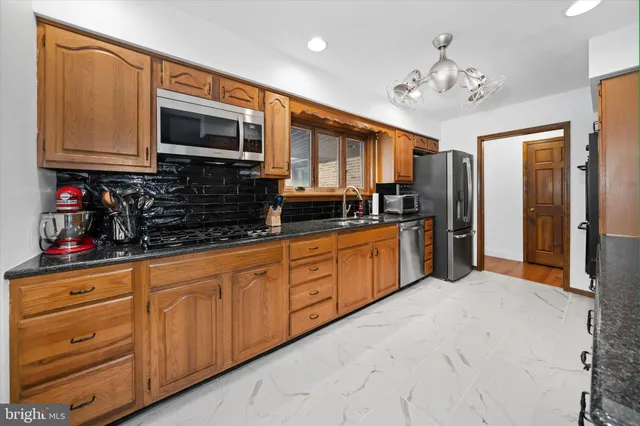 a kitchen with stainless steel appliances granite countertop a stove and cabinets